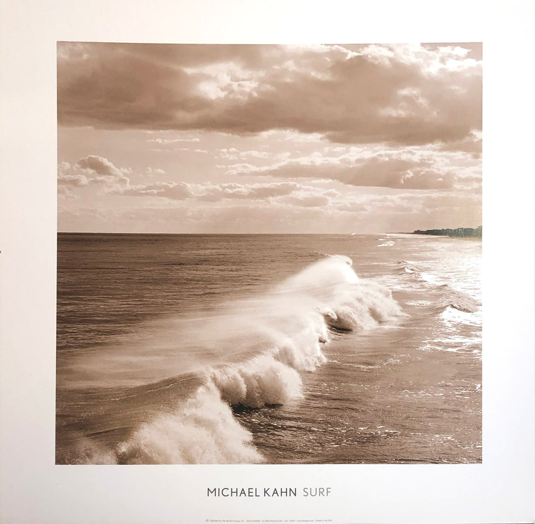 A sepia photograph of waves rolling onto a beach. Clouds float in the sky, beams of light streaking down from the sky.