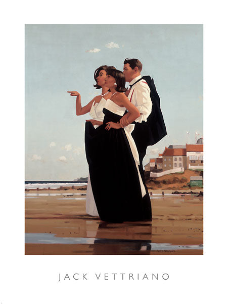 A man in a suit stands behind a pair of women. They stand on a beach with puddles of water. They all wear black and white. One of them women points a finger out along the beach while the other has the man&