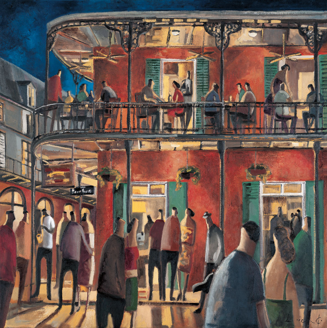 People in and around a red building at night. Lights from the two storey building light up the night. People fill the street, and there are people on the balcony.