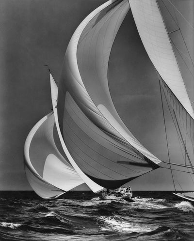 Black and white photograph of a sailboat on choppy water