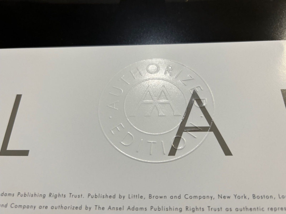 Close-up of a white printed card or cover with a large embossed circular seal reading 'Authorized Edition' and partial large letters on both sides, plus small publisher text along the bottom.