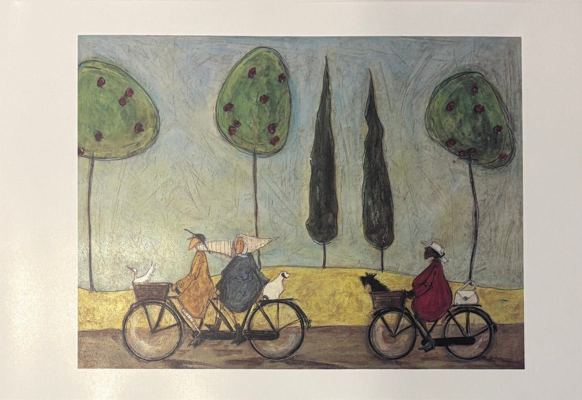 A square art print depicting a whimsical scene of two people riding bicycles with dogs, set against stylized trees and a pale blue sky, mounted on a white wall.