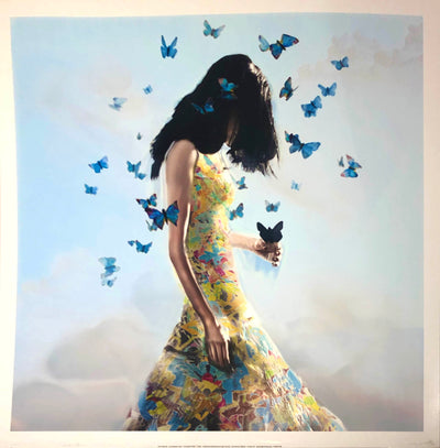 A young woman holds a butterfly. She stands in a floral dress against a blue, cloudy sky. Her dark hair blocks her face. Blue butterflies flutter around her.