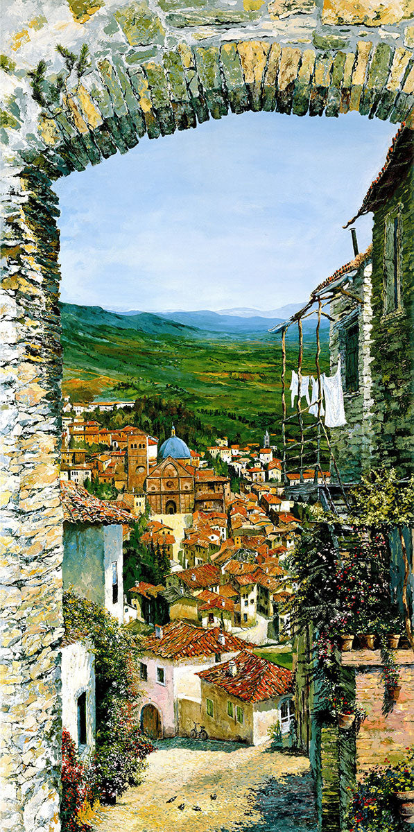 An archway overlooking a town of white buildings with orange roofs huddle together. Amongst the houses is a church with a blue dome. A green landscape can be seen beyond the town. A pocket of blue ocean can be seen in the distance.
