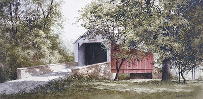A red covered bridge with lush trees around it.