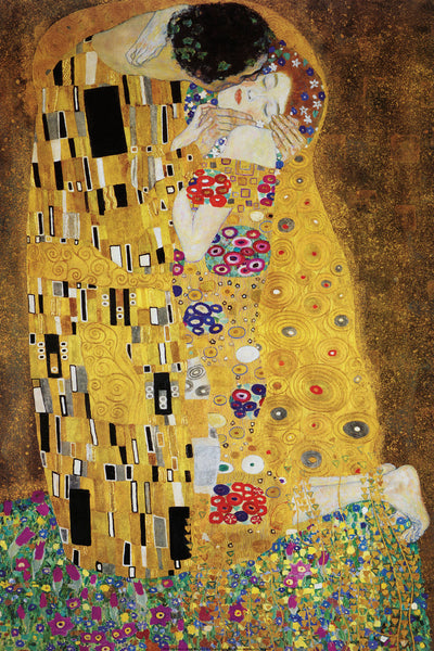 A woman in a gold and floral dress is kissed by a man in a gold and abstract tunic. They sit on the edge of a flowery point.