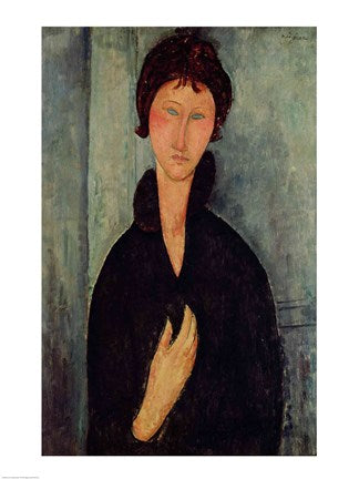 A portrait of a lean woman with her hair tied back and in a black outfit. She is against a blue wall. Her eyes are completely blue.