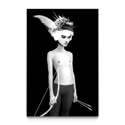 Black and white. A topless, pale young woman in grey pants holds a bow and two arrows by her side. She wears a headdress of feathers, twigs, and flowers. She stands against a black background.