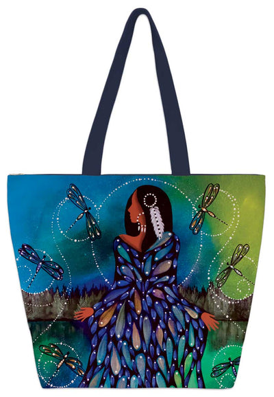 A woman with a feather in her hair wears a blue, petal gown. She stands in a lake surrounded by dragonflies. Both she and the insects have firefly-like halos around them. Printed onto a tote bag.
