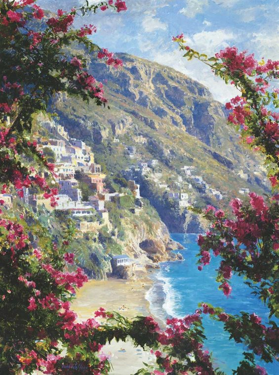 A view of a coastal town on a cliff side, a beach at the foot of the cliff. The cliffs slope down towards to the water. The view is obscured by some pink flowers, as if peeking out from them.