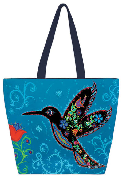 A black, patterned hummingbird, designed almost as if made out of beads, hovers by a red flower. Set against a blue background. Set on a tote bag.