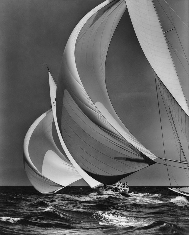 Black and white photograph of a sailboat on choppy water