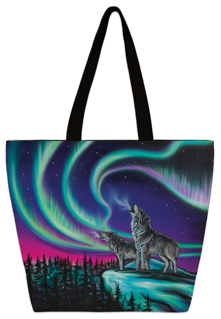 Two wolves stand on a snoy cliff, howling into the night. Northern lights dance in the dark sky. Set on a tote bag.